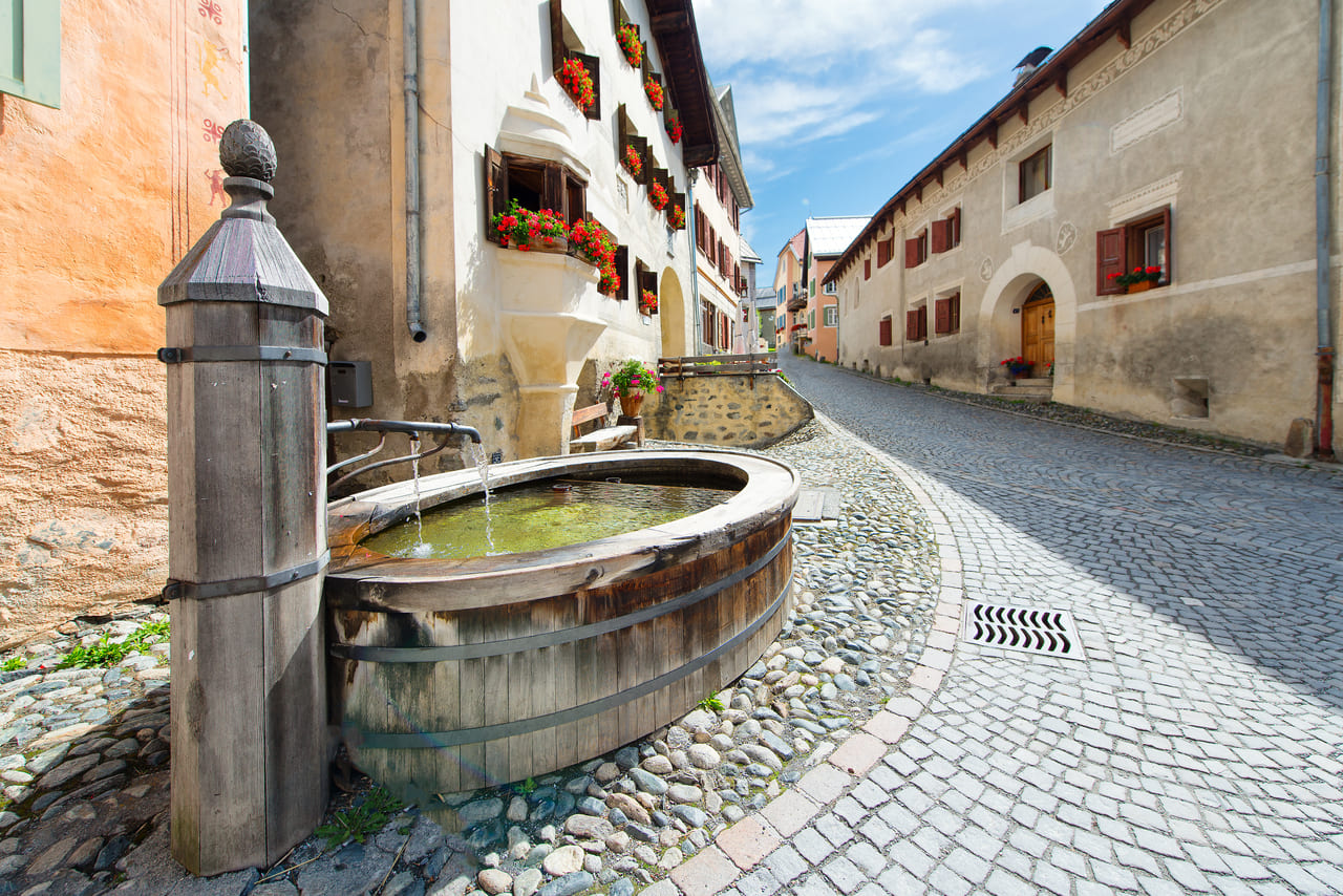 An old wooden fountain graces a cobblestone lane in Vallendas, Switzerland