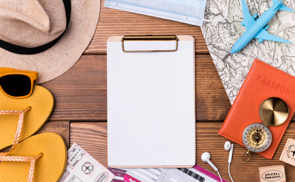 A blank hard board with items that a traveller uses on a holiday